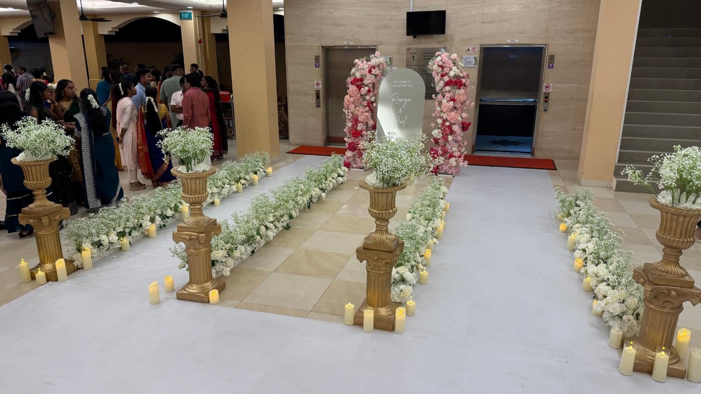 White carpet route from the lift with floral pillars