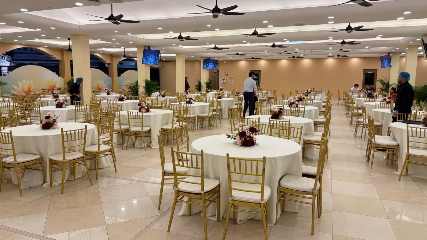 Dining hall with ivory cloths, gold chairs and centrepieces